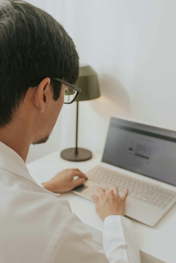 man sitting at laptop typing